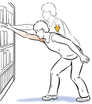 Woman doing shoulder elevation exercise, holding onto bookcase.